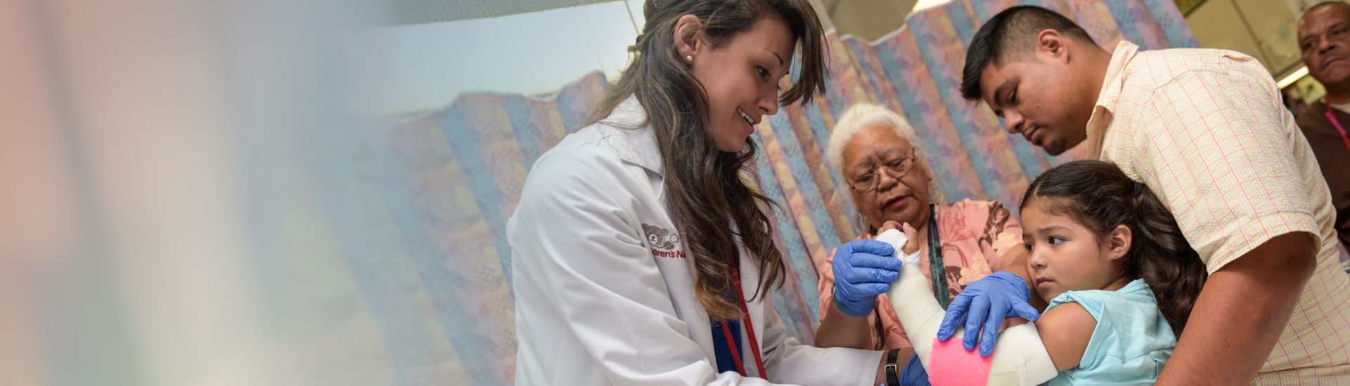 provider treating small child with family present